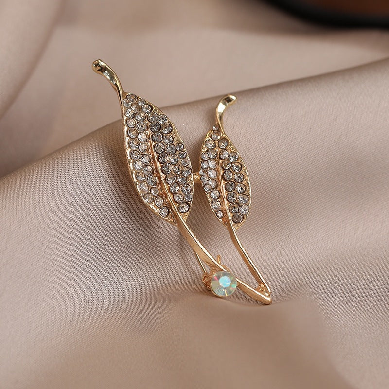 Elegante Brosche mit Blattform und Kristallen Karnz