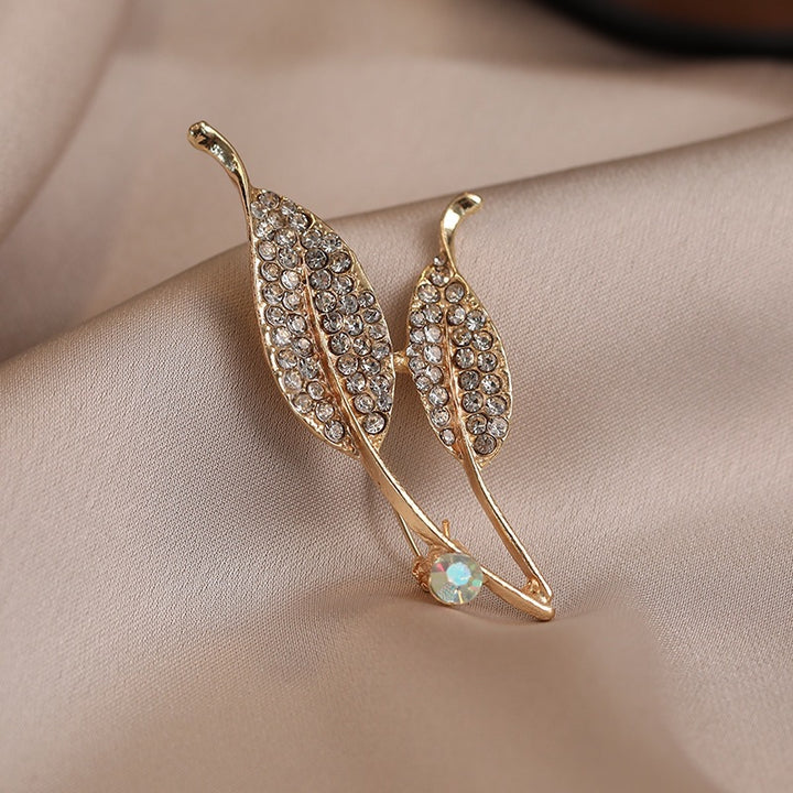 Elegante Brosche mit Blattform und Kristallen Karnz