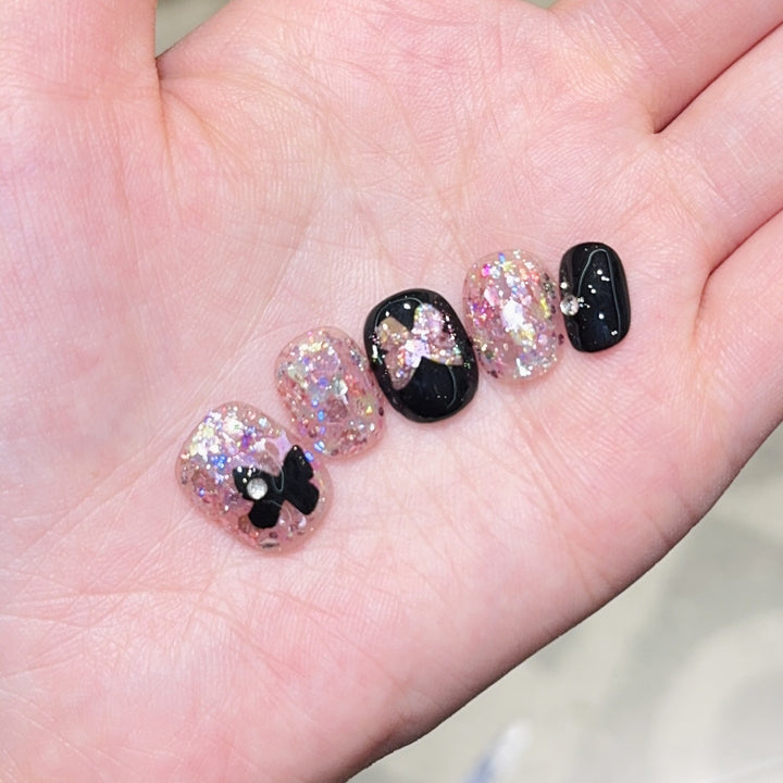 Kunstnägel mit Glitter- und Schleifenakzenten Karnz