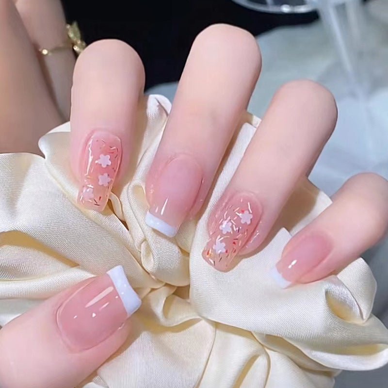 Kunstnagelset mit floralen Verzierungen und elegantem französischen Design Karnz