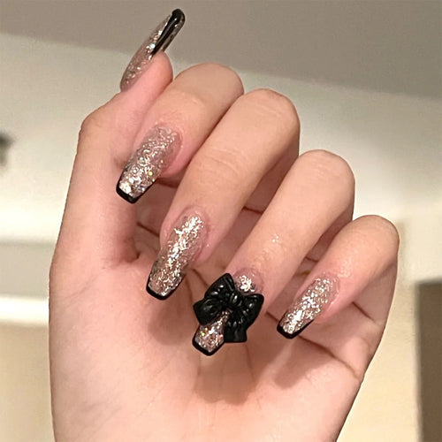 Kunstvolle Nagelverlängerungen mit Glitzer- und Schleifenakzenten Karnz