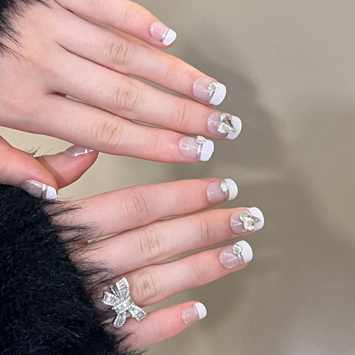 Elegante Nagelkunst mit Glitzerakzenten und Schmuckdetails Karnz