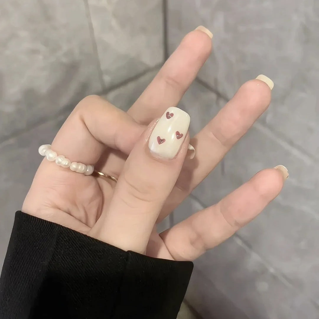 Dekorativer Press-On-Nagelset mit Herz- und Bogenmotiven