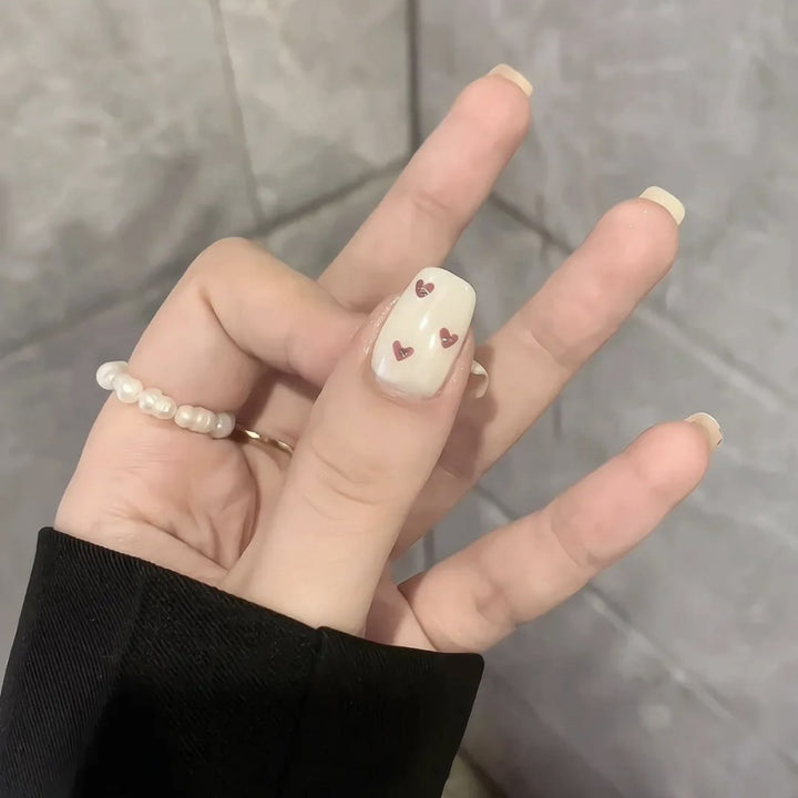 Dekorativer Press-On-Nagelset mit Herz- und Bogenmotiven