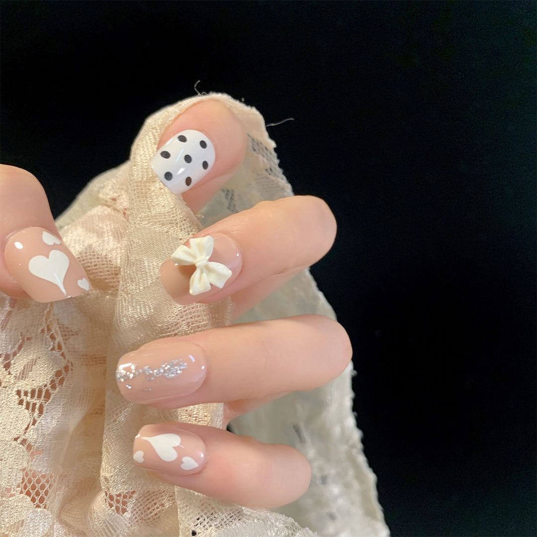 Kunstvolle Nagelkunst mit zarten Blüten- und Herzmotiven Karnz