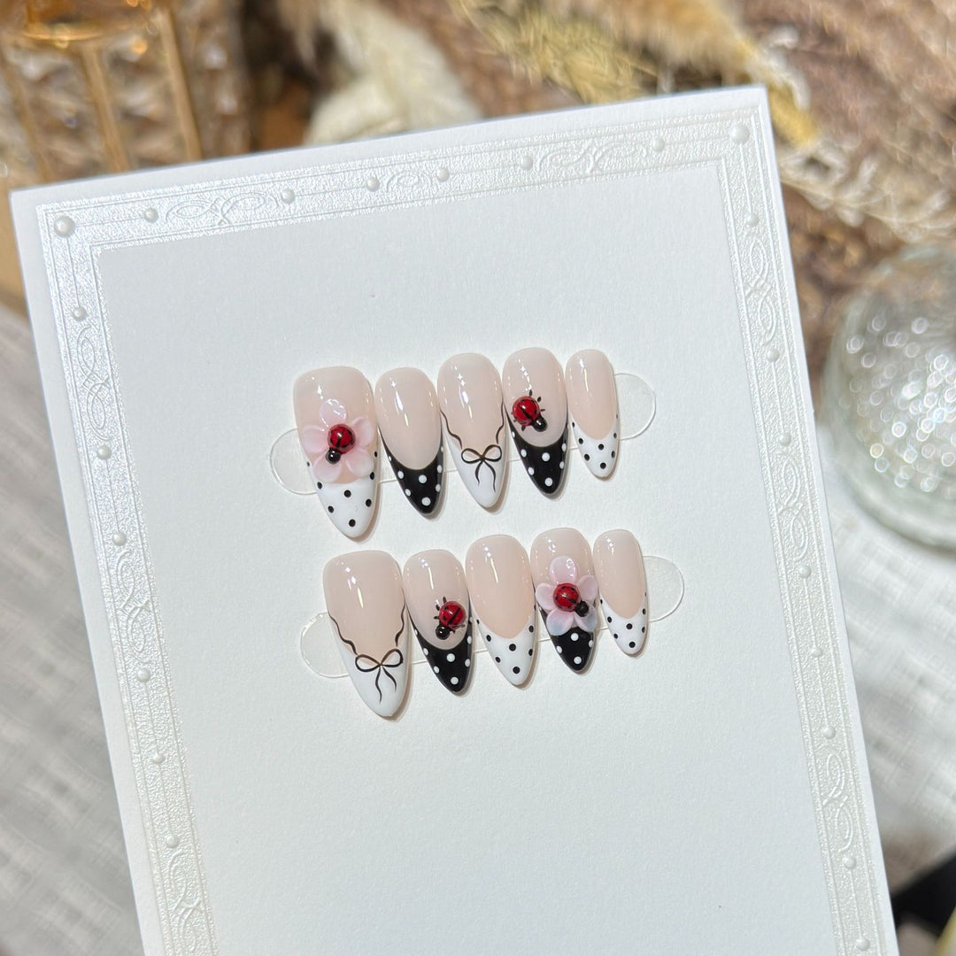 Künstlerisches Stiletto Press-On Nail Set mit floralen und Insektenmustern Karnz
