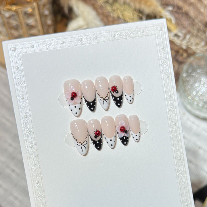 Künstlerisches Stiletto Press-On Nail Set mit floralen und Insektenmustern Karnz