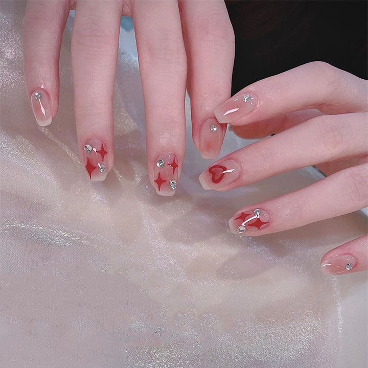 Kunstnagelset mit funkelnden Strassdetails und Herzmotiven Karnz