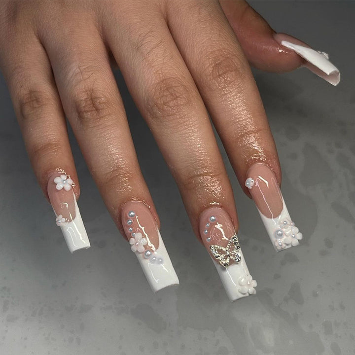 Kunstnagelset mit bezaubernden Blumen- und Schmetterlingsakzenten Karnz