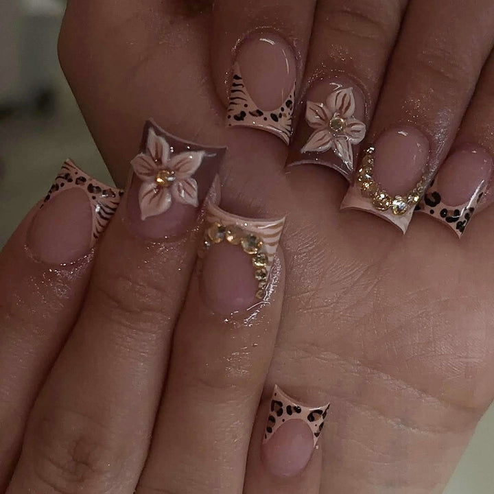 Kunstnagelset mit floralen Verzierungen und eleganten Glitzerdetails Karnz