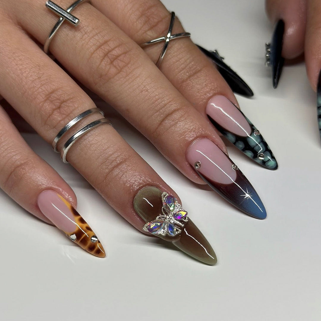 Kunstvolle Nagelverlängerungen mit eleganten Designs und Glitzer Karnz