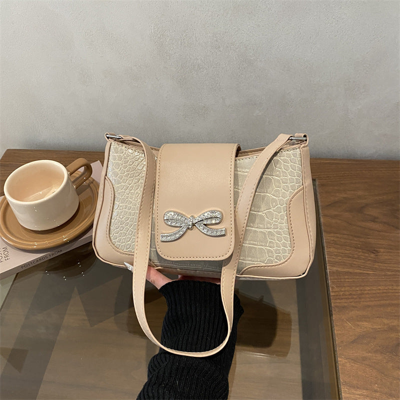 Elegante Handtasche mit Krokodilmuster und Schleifendetail