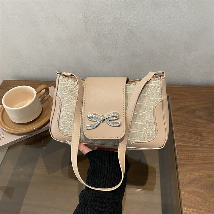 Elegante Handtasche mit Krokodilmuster und Schleifendetail