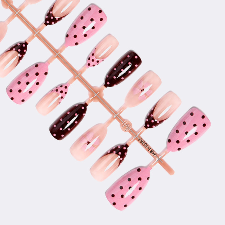 Kunstnagelset mit verspielten Punkten und floralen Akzenten Karnz