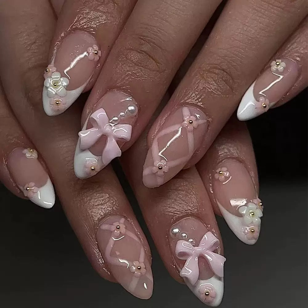Kunstnagelset mit eleganten Schleifen und floralen Akzenten Karnz