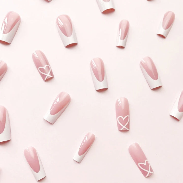 Kunstnagelset mit eleganten French Spitzen und romantischen Herzverzierungen Karnz