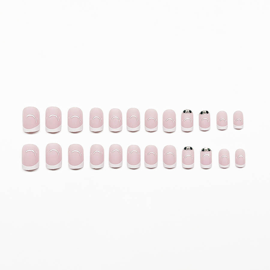 Kunstnagelset mit elegantem französischen Design und glitzernden Akzenten Karnz