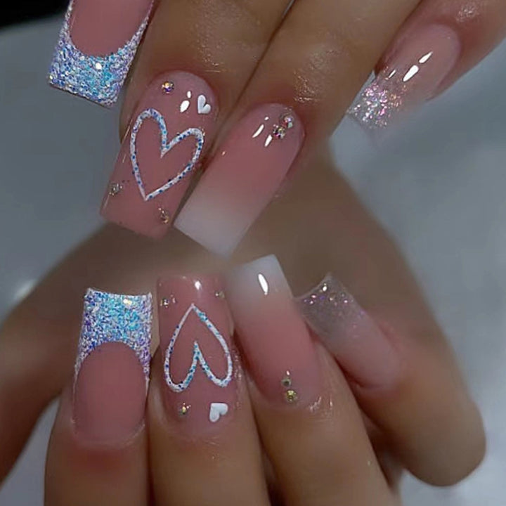 Kunstnägel mit funkelnden Herzmotiven und Glitzerdetails Karnz