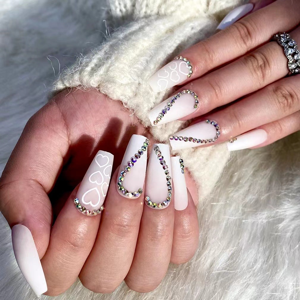 Kunstvolle Nagelverlängerungen mit Herzen-Design und Glitzerakzenten Karnz