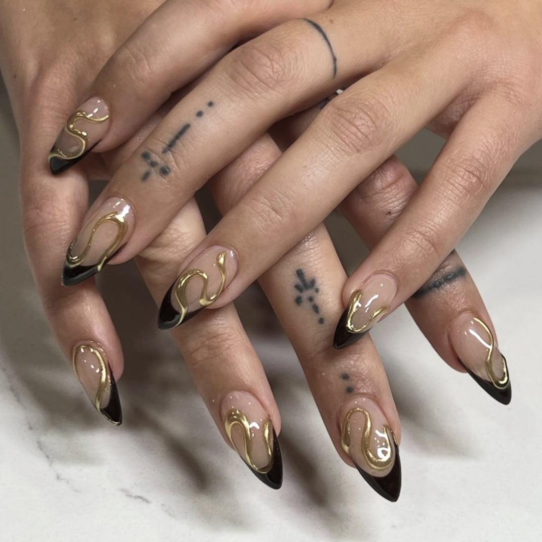 Kunstvolle Stiletto-Nägel mit elegantem Gold-Design Karnz