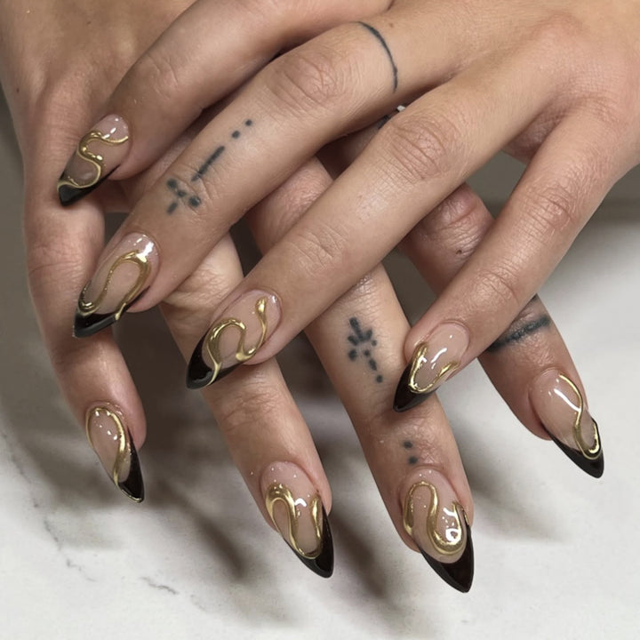 Kunstvolle Stiletto-Nägel mit elegantem Gold-Design Karnz