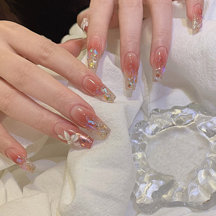 Kunstnagelset mit floralen und glitzernden Akzenten Karnz