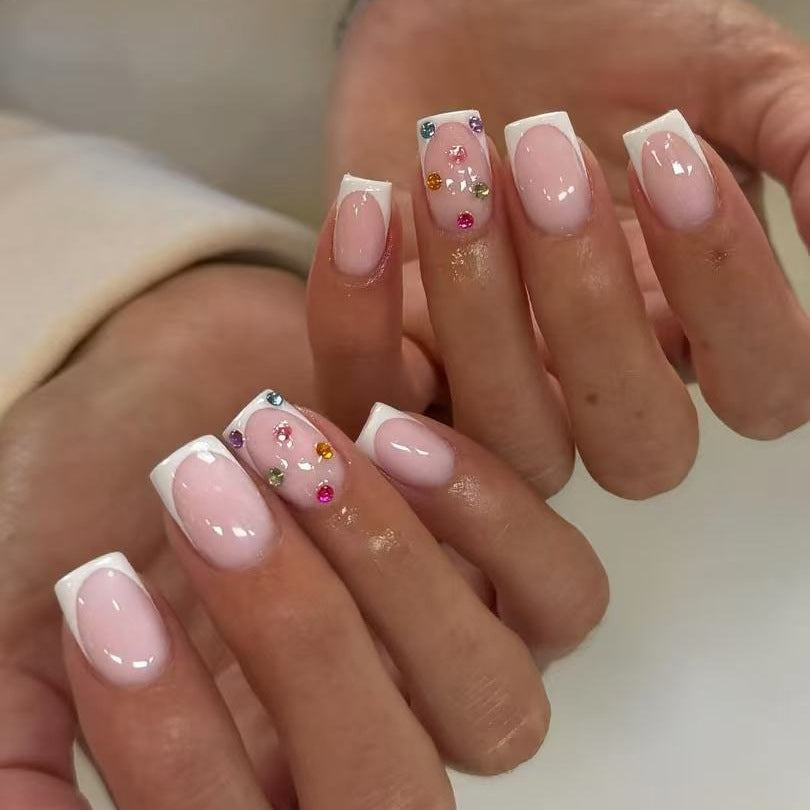 Nagelkunstset mit eleganten French-Spitzen und funkelnden Strassverzierungen Karnz