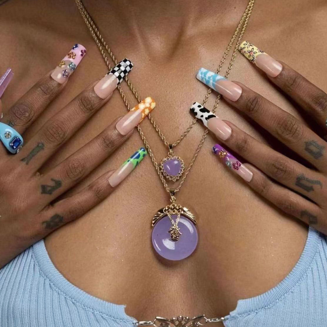Kunstnagelset mit kreativen Designs und schimmernden Akzenten Karnz