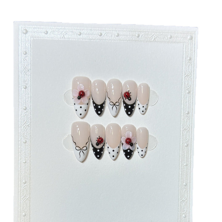 Künstlerisches Stiletto Press-On Nail Set mit floralen und Insektenmustern Karnz