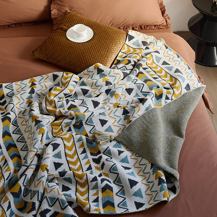 Gemusterte Wohndecke im Ethno-Strickdesign mit Quasten