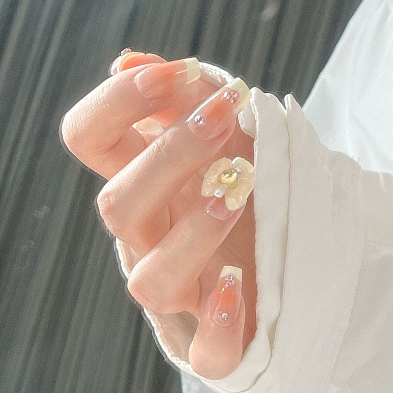 Kunstnagelset mit eleganten Blütenverzierungen und Glitzerakzenten Karnz