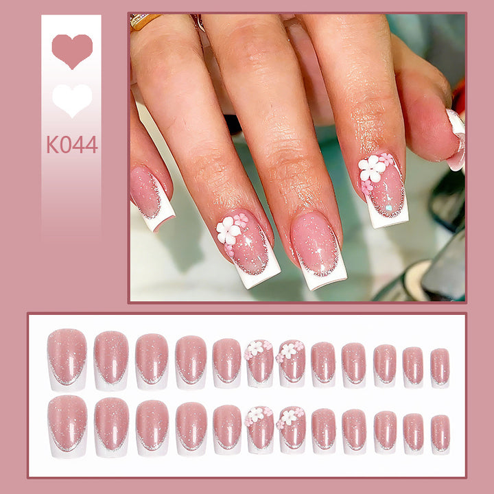 Kunstnagelset mit elegantem French-Tipp und filigranen Blütenverzierungen Karnz