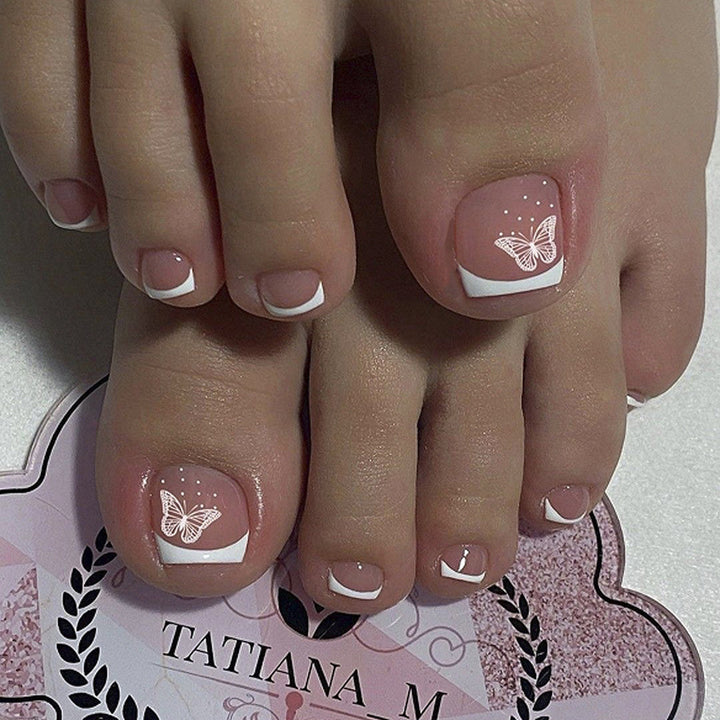 Kunstvolle Fußnagelgestaltung mit eleganten Schmetterlingsmotiven und französischem Design Karnz