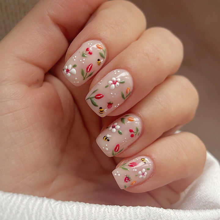 Kunstnagelset mit fröhlichen Blumen- und Bienendesigns Karnz