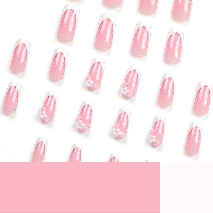 Kunstvolle Nagelverlängerungen mit Glitzer- und Blumenakzenten Karnz