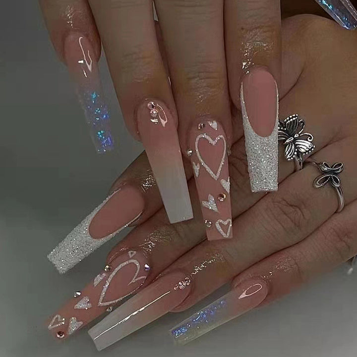 Elegante Kunstnagelspitzen mit Herz- und Glitzermuster Karnz