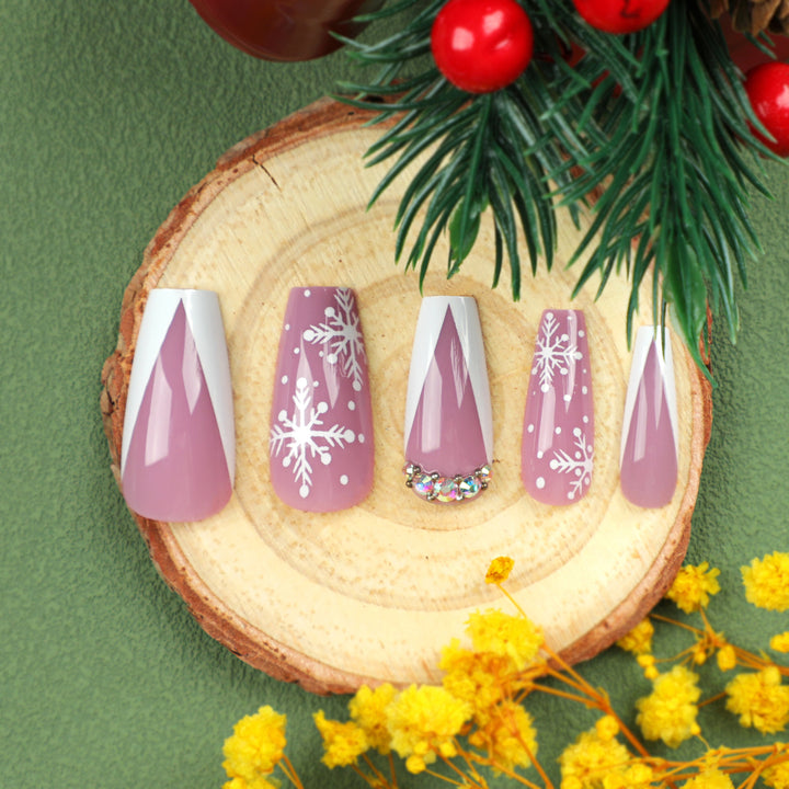 Kunstvolle Nagelverlängerungen mit Schneeflocken-Design und Glitzerakzenten Karnz