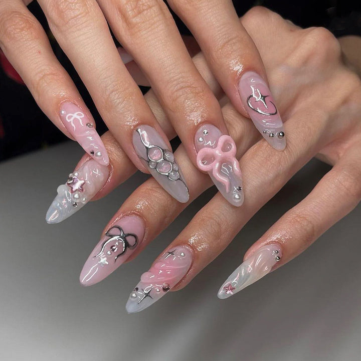 Kunstvolle Stiletto-Nägel im eleganten Design mit kreativen Verzierungen Karnz