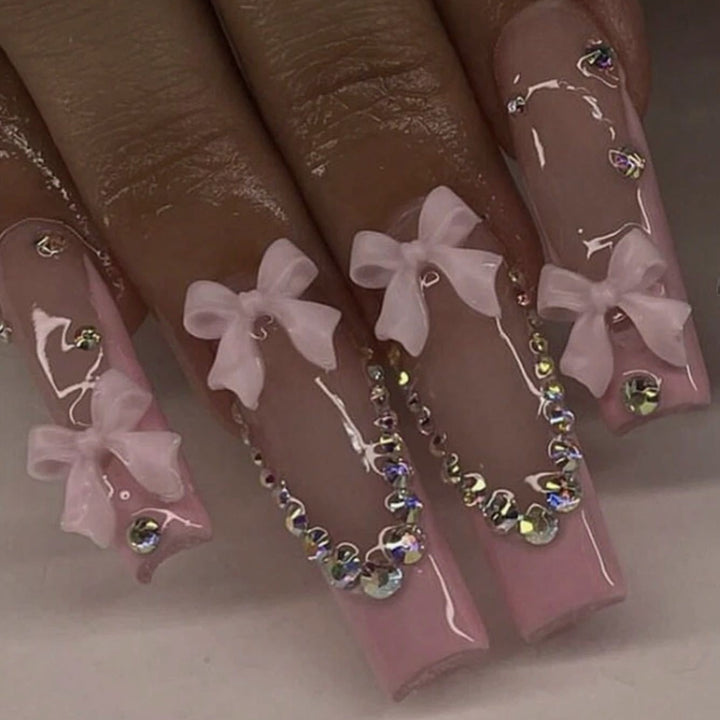 Kunstnagelset mit filigranen Bogenverzierungen und Strassdetails Karnz