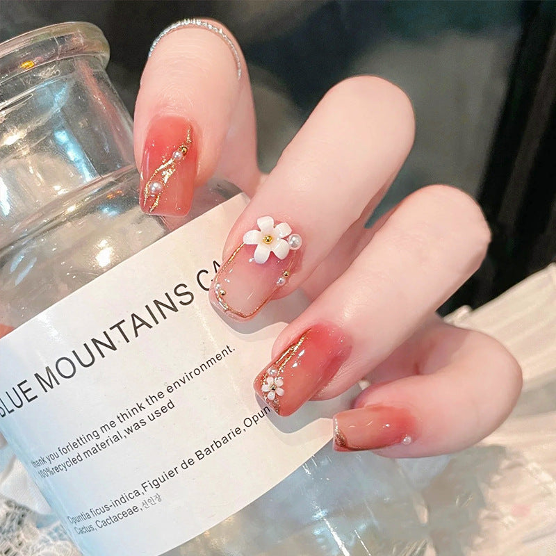 Kunstnagelset mit eleganten Blumendekoren und glamourösen Perlenakzenten Karnz
