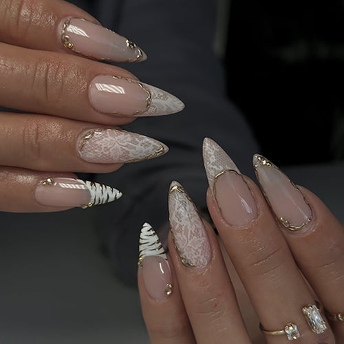 Kunstvolle Stiletto-Nägel mit Gold- und Spitzenverzierungen Karnz
