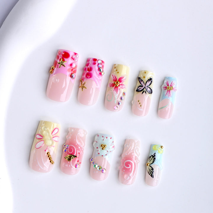 Kunstvolle Fingernägel mit Floralen Akzenten und Glitzer Karnz