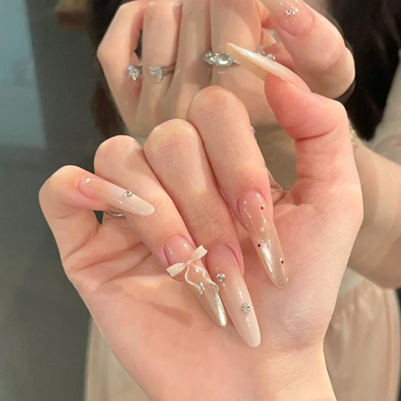 Elegante Stiletto Press-On Nägel mit dekorativem Bogen und Strassakzenten Karnz
