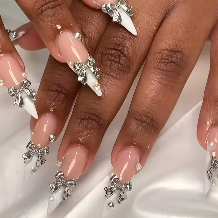 Kunstnagelset mit eleganten Schleifen und funkelnden Akzenten Karnz