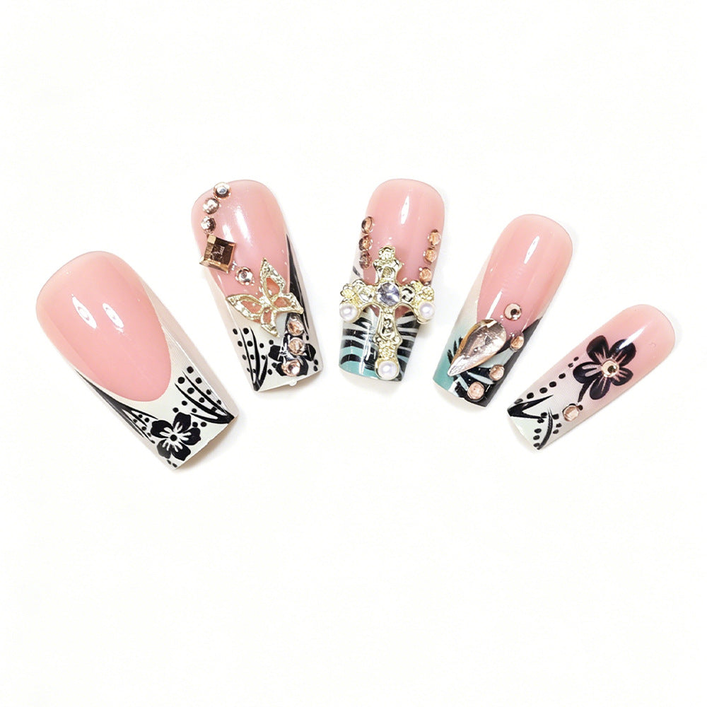Künstlerisches Stiletto-Nageldesign mit floralen Akzenten und Edelsteinen Karnz