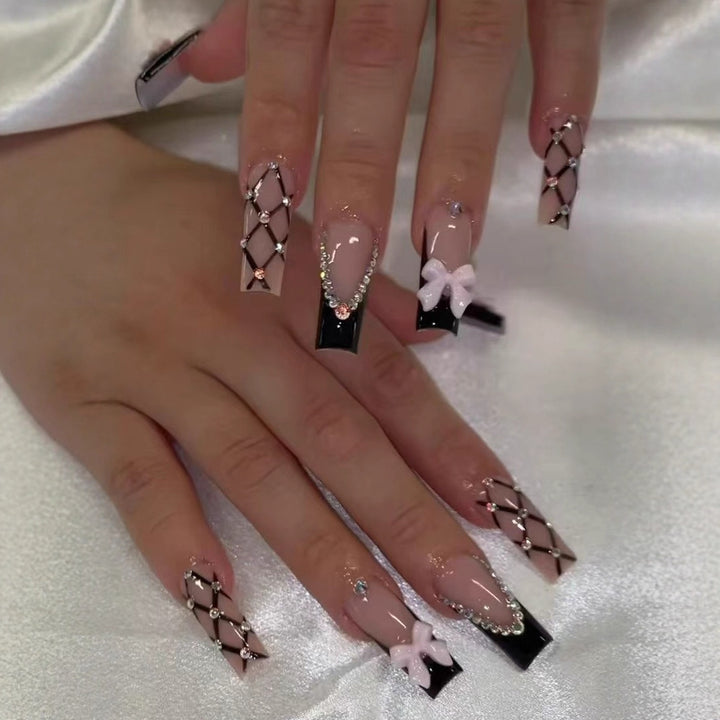 Kunstnagelset mit glamourösen Strass- und Schleifenakzenten Karnz