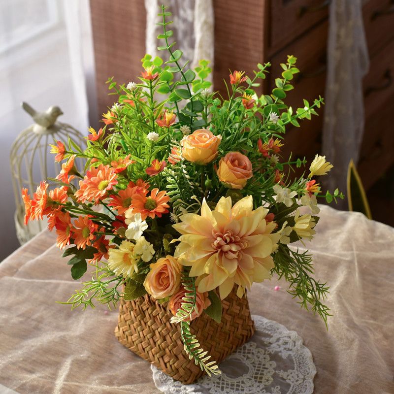 Elegante synthetische Blumenarrangement in geflochtenem Korb