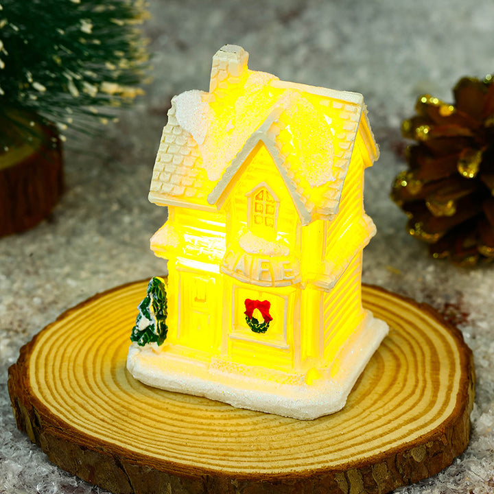 Beleuchtetes Weihnachtsdorfhaus mit festlicher Dekoration Karnz