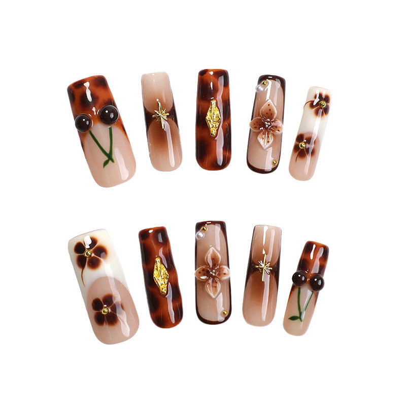 Elegantes Nagelkunstset mit floralen und goldenen Akzenten Karnz