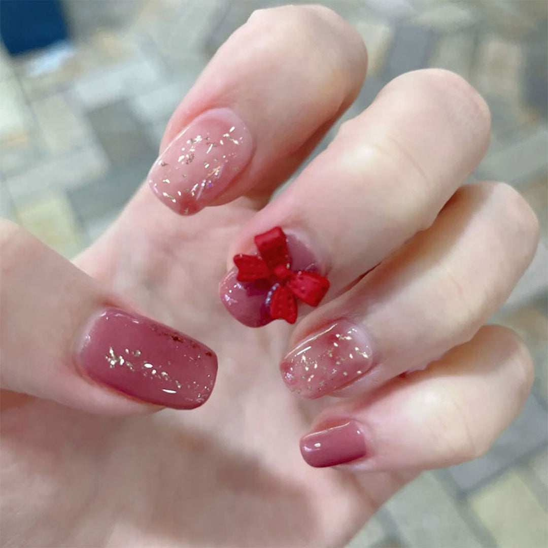 Künstliche Nagelkunst mit Glitzerverzierungen und niedlichem Schleifenmotiv Karnz